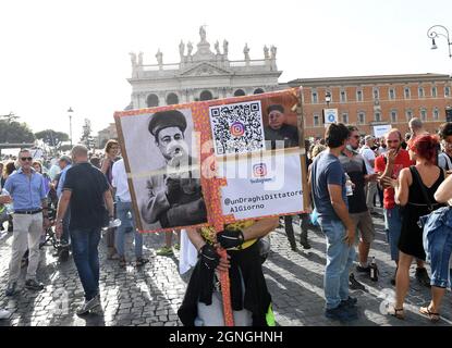 Ein Mann hält am ‘25. September 2021 auf der Piazza San Giovanni im Zentrum Roms ein Plakat des italienischen Premierministers Mario Draghi, gekleidet als Staline und Kim Jong-un, während einer Demonstration gegen die Impfung und den COVID-Gesundheitsausweis (in Italien als „grüner Pass“ bekannt). Tausende von Menschen protestierten gegen die Einführung von Beschränkungen für nicht geimpfte Menschen durch die Regierung. Das Covid-Zertifikat ist erforderlich, um Büros, Kinos, Museen, Hallenbäder oder Sportstadien, Restaurants zu betreten. Foto: Eric Vandeville/ABACAPRESS.COM Stockfoto