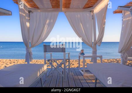 Weiße Vordächer am Strand: Liegestühle am Strand. Luxuriöse Strandzelte in einem Resort in Apulien, Italien. Stockfoto