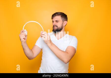Der Mann streut die Kopfhörer aus, um sie auf den Kopf zu stellen. Stockfoto
