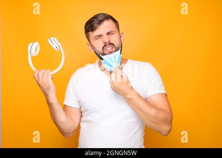 Ein Mann in einer medizinischen Maske und Kopfhörern Stockfoto