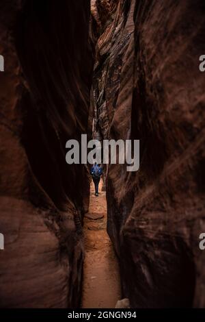 Wanderer beim Spaziergang durch den High Walled Slot Canyon im Süden Utahs Stockfoto