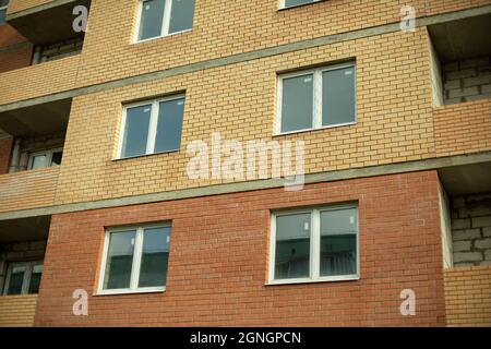 Fenster im neuen Haus. In einem Ziegelhaus sind Kunststofffenster installiert. Neues Gebäude. Stockfoto