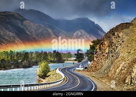 Der Chuysky Trakt eine der schönsten Bergstraßen der Welt, der Chuya-Fluss und der Regenbogen über der Straße Stockfoto