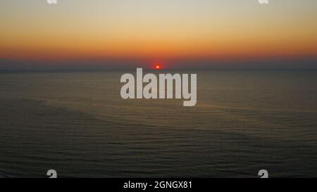 Panoramablick. Früher Sonnenaufgang über dem Schwarzen Meer. Gefilmt von der Drohne aus der Vogelperspektive. Vollständige Entspannung. Schöner Morgenaufgang im hellen Dunst im Herbst. Stockfoto