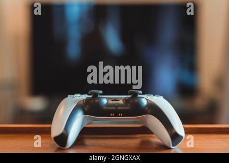 London, Großbritannien – 25. Mai 2021: PlayStation 5 (PS5)-Controller auf dem Tisch in einem flachen, selektiven Fokus. PlayStation 5 ist die neueste Videospielkonsole Stockfoto