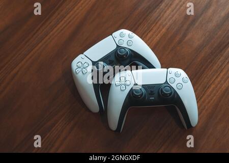 London, Großbritannien - 25. Mai 2021: PlayStation 5 (PS5)-Controller auf einem hölzernen Couchtisch. PlayStation 5 ist die neueste Videospielkonsole von Sony veröffentlicht i Stockfoto