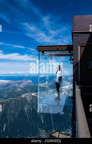 Chamonix, Frankreich - 10. Juli 2021. Tourist steht in der Glasbox "Step into the Void" auf dem Gipfel des Aiguille Du Midi (3842m) oberhalb von Chamonix Stockfoto