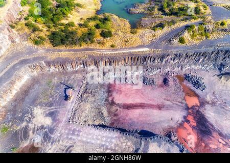 Grund der Tagebaubasaltmine in NSW, Australien - von oben aus Sicht über schwere Baggermaschinen und Felsnadelgesteine. Stockfoto