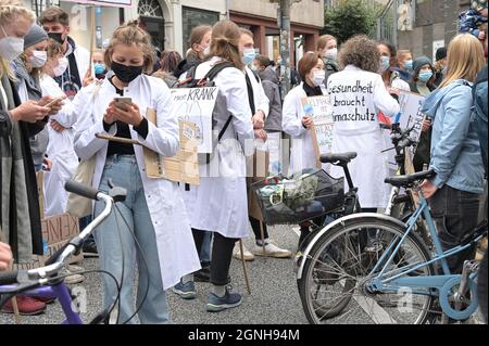 Lübeck, 24. September 2021: Junge Menschen aus dem Medizinbereich mit deutschen Slogans auf ihren weißen Mänteln, das heißt: Gesundheit braucht Klima Stockfoto