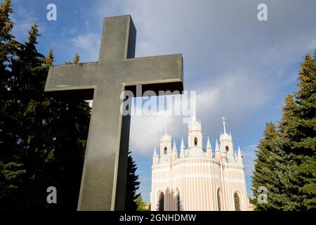 Das Granitkreuz und die Geburtskirche von Johannes dem Täufer 'Ches-Menskaya'. Russland, Sankt Petersburg, 7. September 2021 Stockfoto