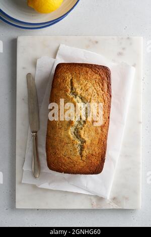 Zitronenbrot mit Mohnsamen. Hausgemachte rustikale Bäckerei. Vertikale, flache Verlegung Stockfoto