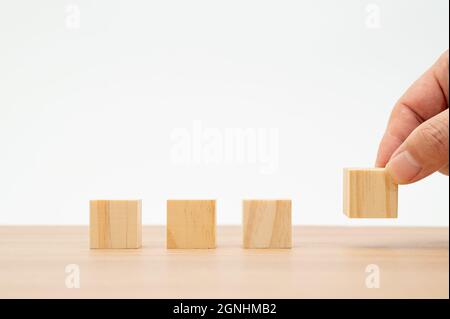 Die Hände eines Mannes, der Holzblöcke stapelt. Geschäftskonzept Stockfoto
