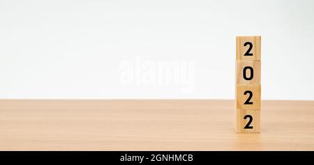 Holzwürfel mit der Nummer 2022 auf einem Holztisch mit weißem Hintergrund Stockfoto