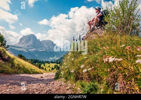 Wanderer bewundern die fantastische Aussicht auf das Grödner Tal mit dem Langkofel im Hintergrund. Malerische Sommerszene des Puez-Geisler-Nationalparks Stockfoto
