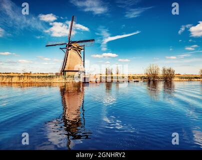 Farbenfrohe Frühlingsansicht des Kanals in den Niederlanden. Berühmte niederländische Windmühlen in Kinderdijk, einem UNESCO-Weltkulturerbe. Hintergrund des Reisekonzepts. Stockfoto
