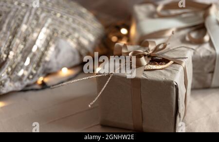 Nahaufnahme einer Weihnachtsschachtel, geschmückt mit getrockneten Blumen und einer trockenen Orange, eingewickelt in Bastelpapier. Stockfoto