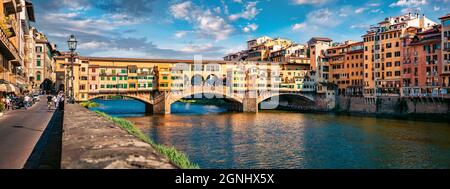 Panoramablick auf die mittelalterliche gewölbte Flussbrücke mit römischen Ursprüngen - Ponte Vecchio über den Fluss Arno. Bunte sommerliche Stadtansicht von Florenz, Italien, Europ Stockfoto