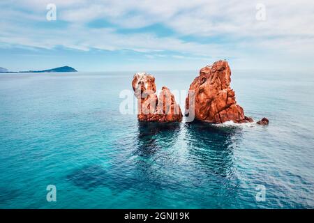 Blick von der fliegenden Drohne. Ruhige Frühlingsansicht der Red Rocks Gli Scogli Rossi - Faraglioni am Strand von di Cea. Luftaufnahme der Insel Sardinien, Ital Stockfoto