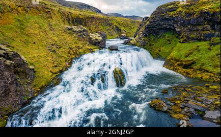 Blick von der fliegenden Drohne auf den Wasserfall auf dem Skoga Fluss. Herrliche Sommeransicht von der Touristenwanderung vom berühmten Skogafoss Wasserfall bis zur Spitze des Flusses Stockfoto