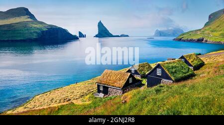 Sonnige Sommerszene von Bour Village mit typischen Turf-Top-Häusern und Tindholmur Klippen im Hintergrund. Panoramablick auf die Insel Vagar, Färöer, De Stockfoto