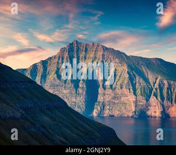 Fantastischer Sommersonnenaufgang auf den Färöern, Dänemark, Europa. Erste Sonnenlicht glühenden Bergrücken. Schönheit der Natur Konzept Hintergrund. Stockfoto