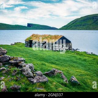 Einsames Haus mit Rasen-Top an der Küste des Sorvagsvatn See, Vagar Insel. Düstere Morgenansicht der Färöer Inseln, Königreich Dänemark, Europa. Reisen Stockfoto
