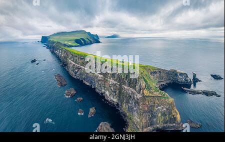 Blick von der fliegenden Drohne. Düstere Sommerszene der Insel Mykines mit altem Leuchtturm. Dramatische Morgenansicht der Färöer Inseln, Königreich Dänemark, Europa. Stockfoto