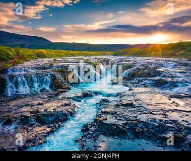 Blick von der fliegenden Drohne. Aufregender Sommersonnenaufgang am Bruarfoss Wasserfall, abgeschiedener Ort mit kaskadierenden blauen Gewässern. Beeindruckende Morgenszene von Island, Stockfoto