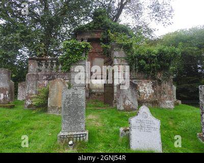 Das Gewölbe von Patrick Heron & Familie liegt auf dem Gelände der Monigaff (Minnigaff) Kirche oder Kirk, in der Nähe von Newton Stewart, Dumfries und Galloway. Die "neue" Kirche ist eine Kirche unter dem B-Denkmalschutz, die 1836 nach einem neugotischen Entwurf von William Burn erbaut wurde. Innerhalb des gleichen Geländes befinden sich die Ruinen der alten Kirche mit dazugehörigen Begräbnissen, die mit alten Grabsteinen markiert sind. Es wurde an der Stelle eines älteren motte- und bailey-Schlosses errichtet Stockfoto