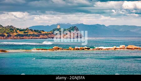Panoramablick auf den Torre di San Macario Turm am Morgen vom Strand von Nora. Bunte Sommerszene von Sardinien, Italien, Europa. Helle Meereslandschaft von Medi Stockfoto