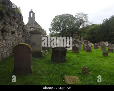 Auf dem Gelände der Monigaff (Minnigaff) Kirche oder Kirk, in der Nähe von Newton Stewart, Dumfries und Galloway. Die "neue" Kirche ist eine Kirche unter dem B-Denkmalschutz, die 1836 nach einem neugotischen Entwurf von William Burn erbaut wurde. Auf dem gleichen Gelände befinden sich die Ruinen der alten Kirche (hier abgebildet) mit den dazugehörigen Begräbnissen, die mit alten Grabsteinen markiert sind. Es wurde an der Stelle eines älteren motte- und bailey-Schlosses errichtet Stockfoto