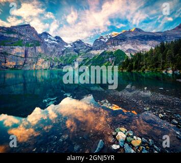 Dramatischer Sommersonnenaufgang auf dem einzigartigen See - Oeschinen (Oeschinensee), UNESCO-Weltkulturerbe. Ruhige Outdoor-Szene in den Berner Oberland Alpen, Schweizlan Stockfoto