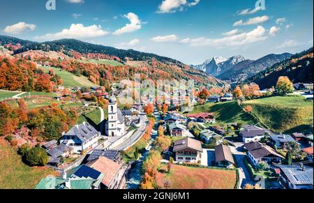 Blick von der fliegenden Drohne. Sonnenszene am Morgen der Pfarrkirche St. Sebastian. Malerische Herbstansicht der bayerischen Alpen, Au-Dorf. Attraktive Outdoo Stockfoto