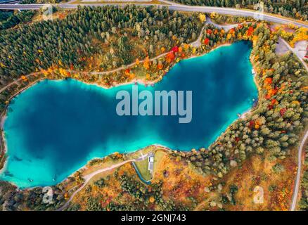 Gerader Blick von der fliegenden Drohne auf den Urisee See. Luftaufnahme des Herbstwaldes, Österreich, Europa. Schönheit der Natur Konzept Hintergrund. Stockfoto