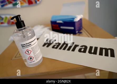 Aachen, Deutschland. September 2021. Eine Flasche Desinfektionsmittel steht neben dem Wahlplatzschild in einem Wahllokal. Quelle: Rolf Vennenbernd/dpa/Alamy Live News Stockfoto