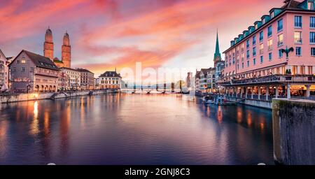 Dramatische Abendansicht der Fraumünster- und Grossmünster-Kirchen. Beleuchtetes Herbststadtbild von Zürich, Schweiz, Europa. Sonnenuntergang am Limmat River. T Stockfoto
