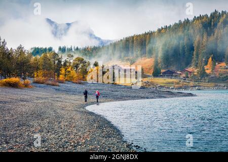 Zwei Touristen, die am Oeschinensee spazieren. Attraktive Morgenszene der Schweizer Alpen. Wunderschöne Herbstlandschaft der Schweiz, Europa. Wandern Und Stockfoto