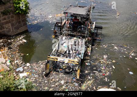 Hyderabad, Indien.21. September 2021.Eine schwimmende Müllsammelmaschine entfernt am nächsten Tag nach dem Eintauchen der Ganesh-Idole Müll aus dem hussain sagar See Stockfoto