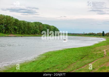Idyllische grüne Flusslandschaft. Fließender Fluss mit grünen Bäumen am Ufer Stockfoto