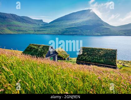 Frische grüne Aussicht auf das Dorf Bour. Herrliche Morgenszene mit typischen Häusern auf der Insel Vagar, Färöer, Königreich Dänemark, Europa. Reisekons Stockfoto