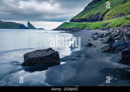 Dramatische Sommerszene der Färöer Inseln und Tindholmur Klippen im Hintergrund. Balck Sandstrand auf der Insel Vagar, Dänemark, Europa. Reisekonzept hinten Stockfoto