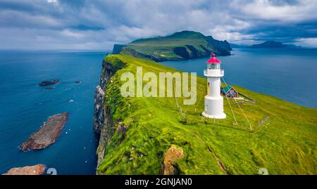 Düsterer Blick von fliegender Drohne auf Mykines Insel mit altem Leuchtturm. Attraktive Morgenlandschaft der Färöer Inseln, Dänemark, Europa. Dramatische Seestücke von Stockfoto