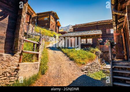 Typische Holzhäuser im Dorf Zermatt. Helle Sonnenszene der Schweizer Alpen, des Walliser Kantons, der Schweiz, Europas. Hintergrund des Reisekonzepts. Stockfoto