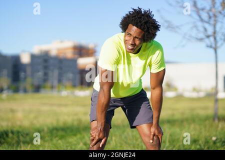 Schwarzer Mann mit Afro-Haar nach dem Training erschöpft. Stockfoto