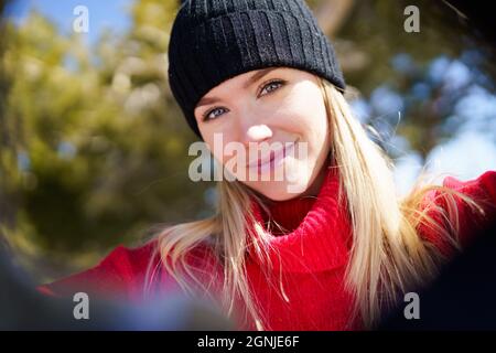 Junge blonde Frau, die im Winter ein Selfie in einem verschneiten Bergwald gemacht hat. Stockfoto