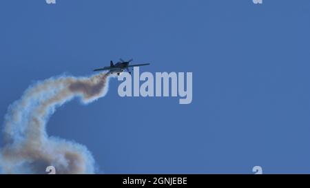 Maribor Airshow Slovenia 15. AUGUST 2021 kleines Propellerflugzeug am blauen Himmel mit weißem Rauch. Speicherplatz kopieren. MX Aircraft MXS von Veres Zoltan Stockfoto