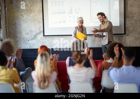 Die Mitarbeiter des Unternehmens gratulieren zu einer gelungenen Präsentation in angenehmer Atmosphäre im Konferenzraum. Mitarbeiter, Büro, Arbeit Stockfoto