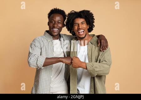 Portrait Von Zwei Fröhlichen Schwarzen, Die Die Geste Des Faustbumpfens Umarmen Und Machen Stockfoto