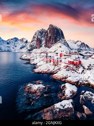 Erstaunlicher Sonnenuntergang auf dem beliebten Touristenziel - Hafen Hamnoy mit Festhaeltinden-Berg im Hintergrund, Norwegen. Bunte Abendszene der Lofoten Isl Stockfoto