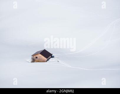 Luftaufnahme mit einer verlassene Hütte oder Hütte in den Bergen inmitten eines Meeres aus weißem Neuschnee Stockfoto